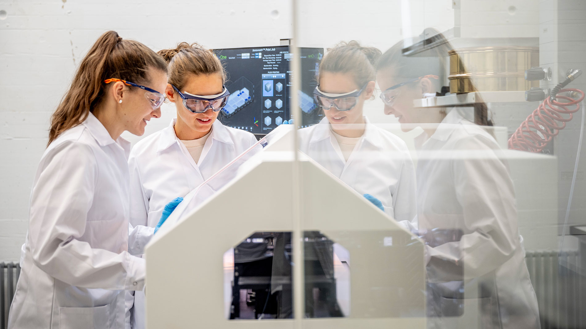 Forscherinnen arbeiten gemeinsam an einem Laborgerät zur Materialanalyse