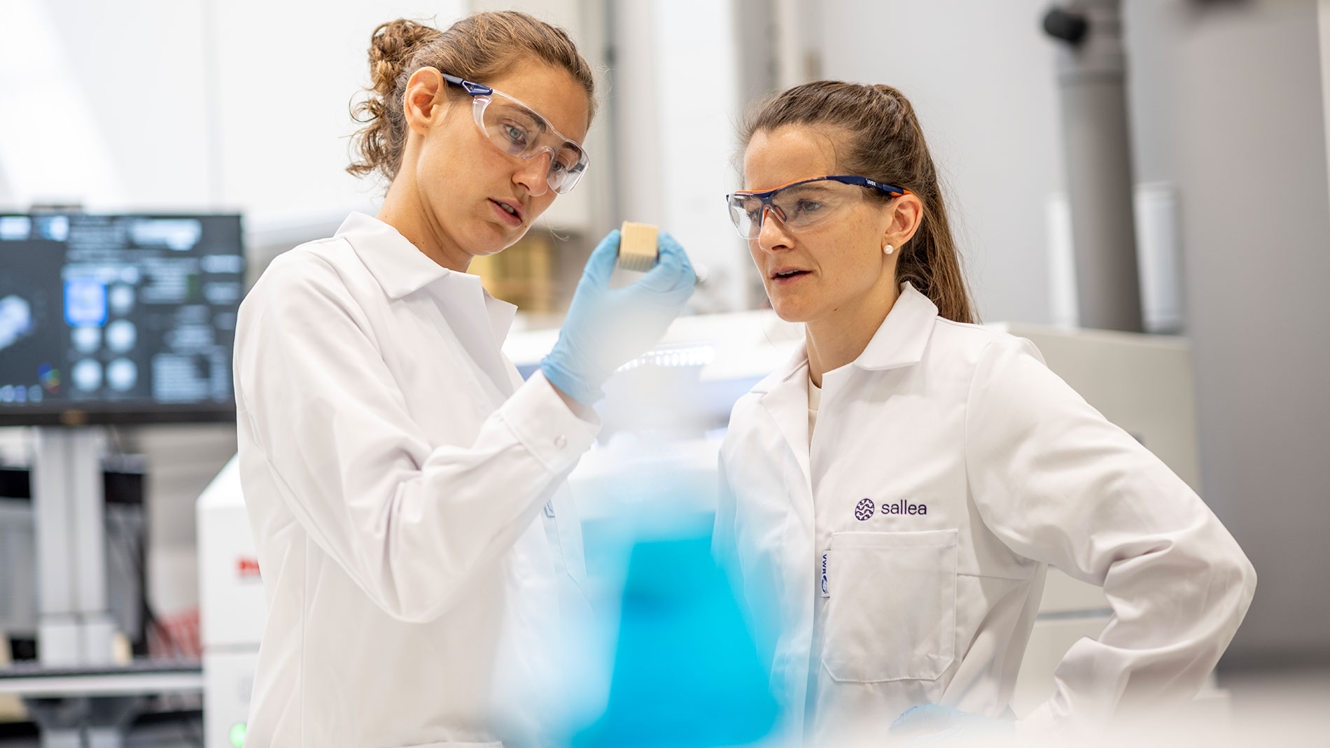 Zwei Forscherinnen im Labor analysieren ein Materialmuster