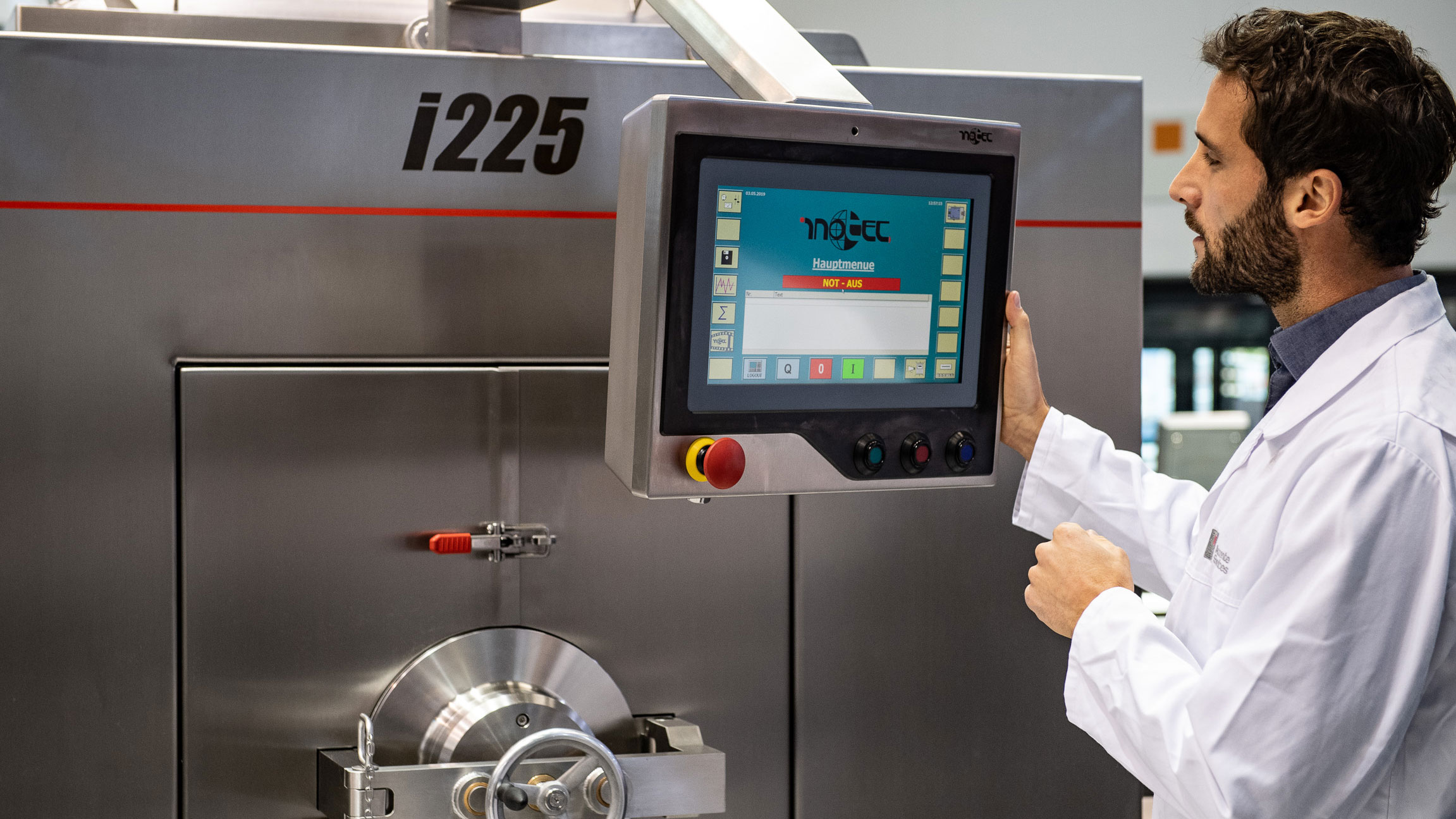 Technician operating an industrial food machine via digital touchscreen