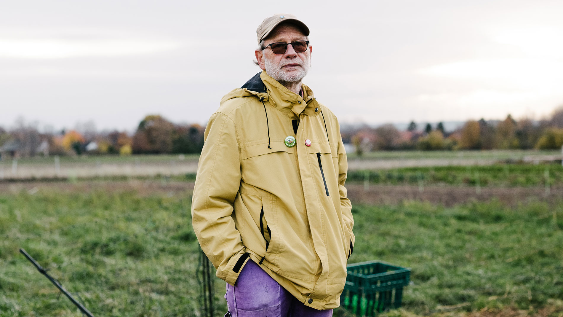 Farmer Heiner Schrobsdorff in yellow jacket standing on field looking into the distance