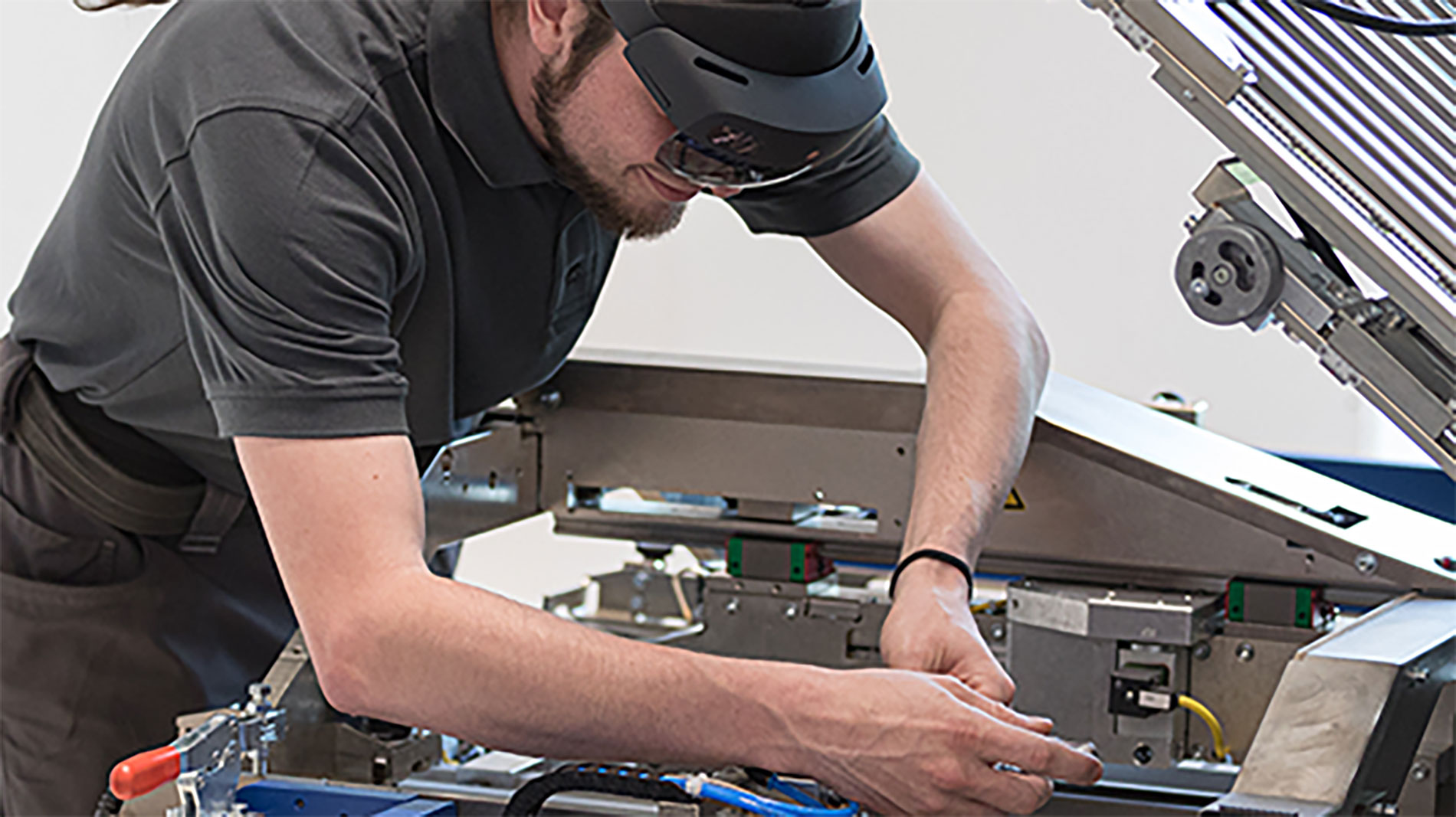 Technician using AR glasses while working on industrial machinery