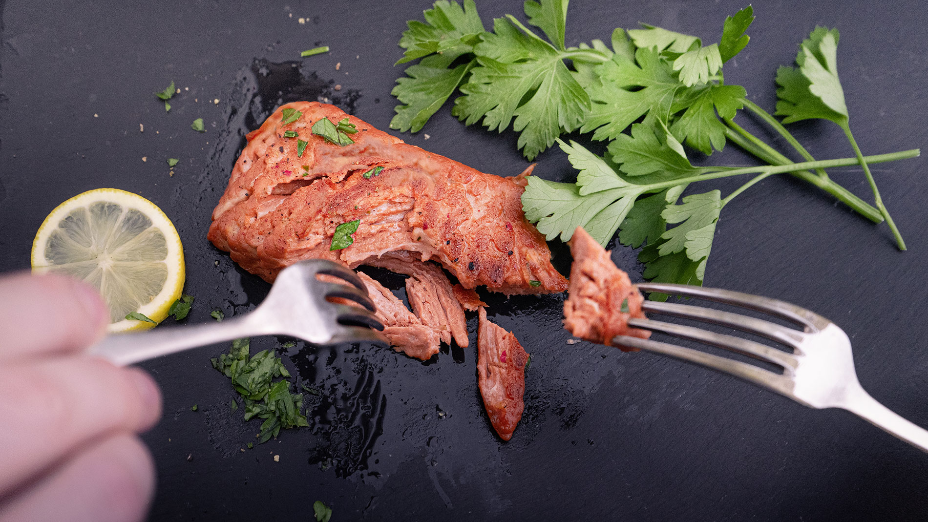 Veganes Filet wird mit zwei Gabeln zerteilt