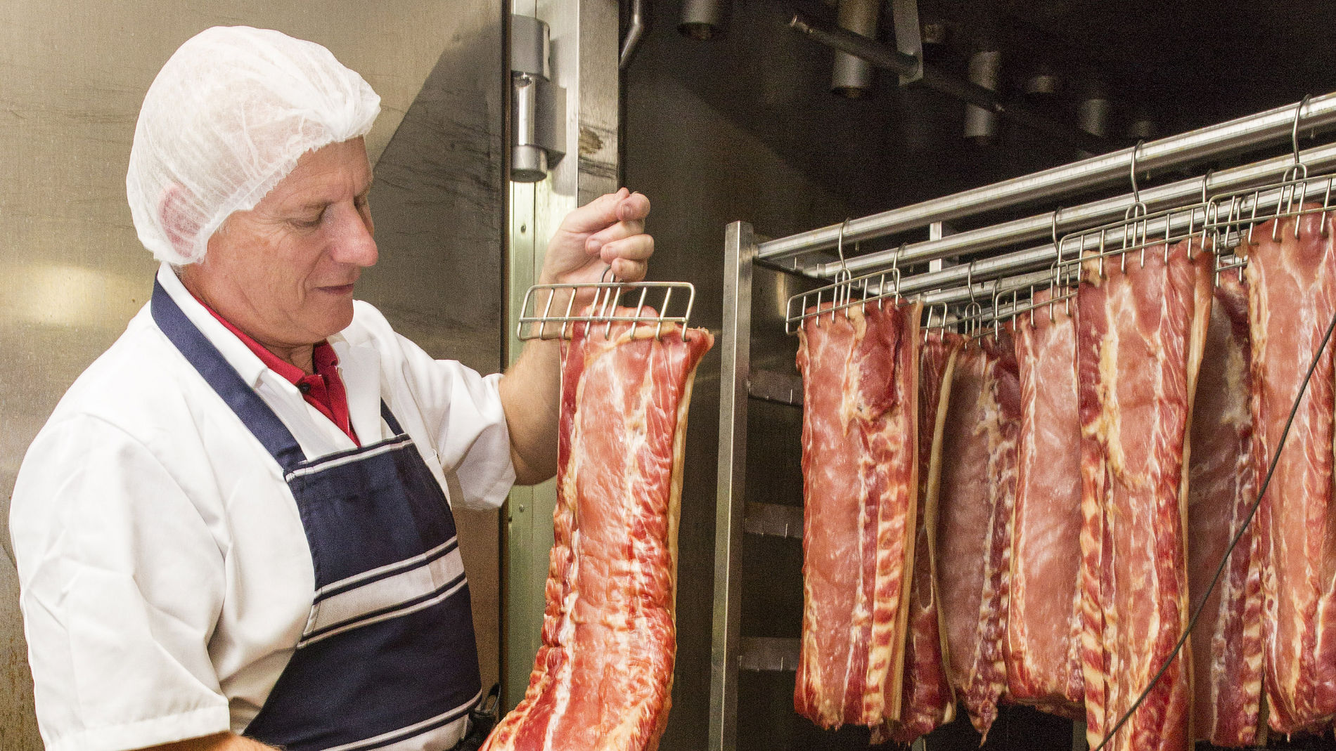 Franz Knoll checks the pieces of meat hanging in the maturing room