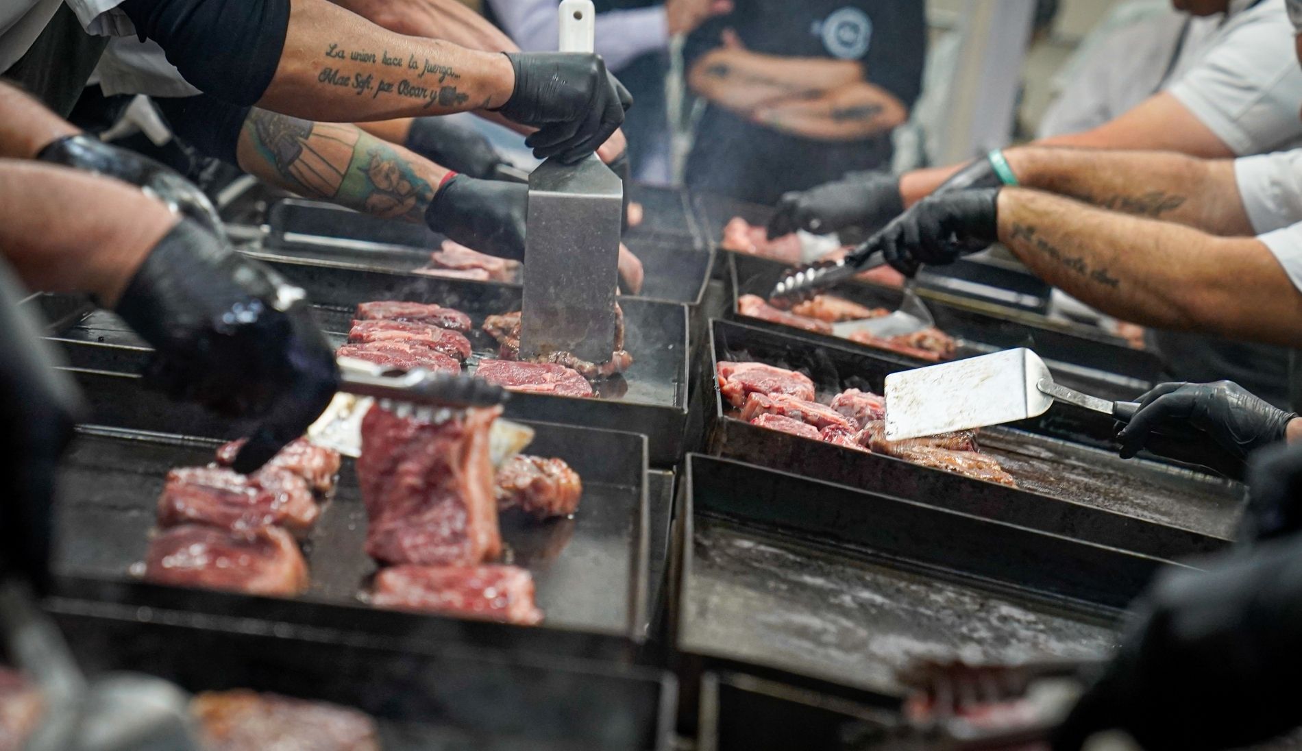 Köche, die Fleischproben auf Grillplatten zubereiten